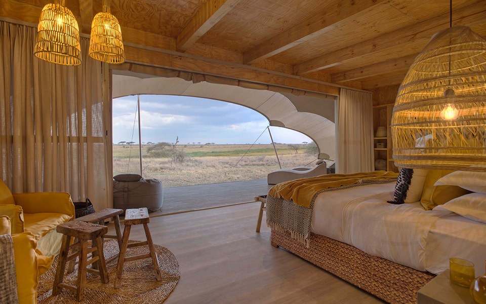 Ein großes Schlafzimmer mit einem Doppelbett und Aussicht auf die Serengeti
