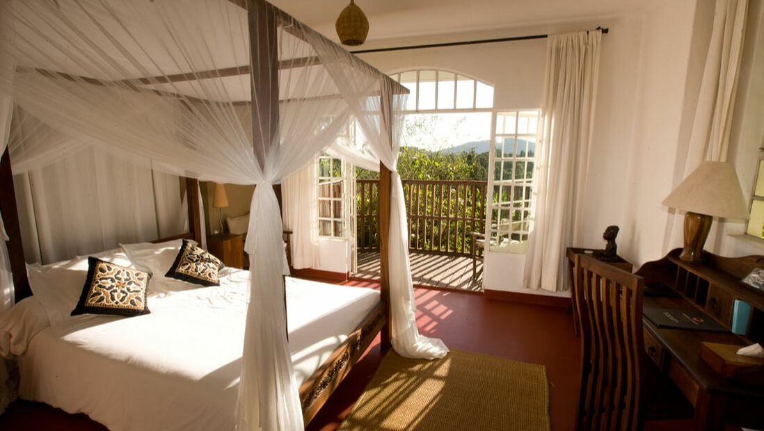Ein gemütliches und großes Doppelbett in einem Schlafzimmer mit Balkon