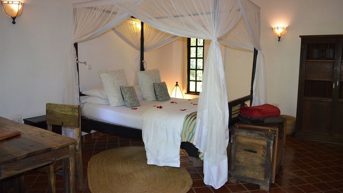 Ein Bett mit Mosquito-Netzen auf einem Fliesenboden