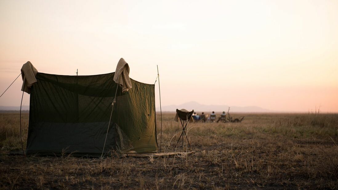 Ein einzelnes rustikales Zelt in der Abenddämmerung in der Savanne