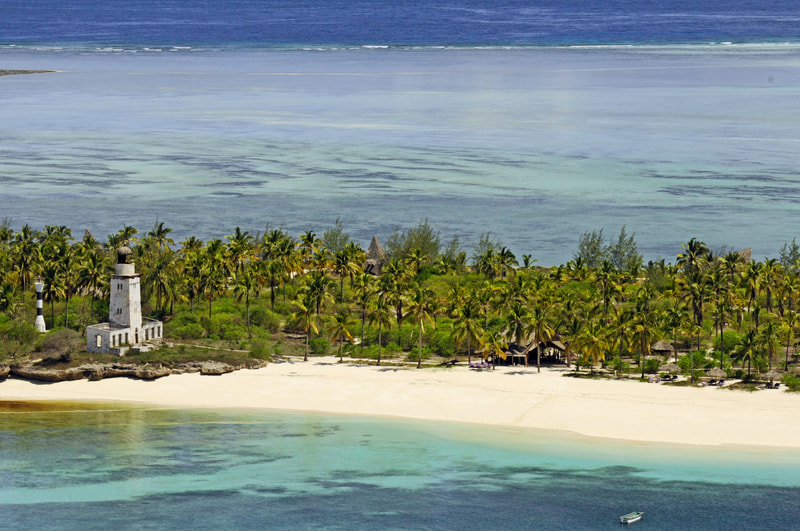Eine Insel mit einem alten Leuchtturm und vielen Palmen im Meer