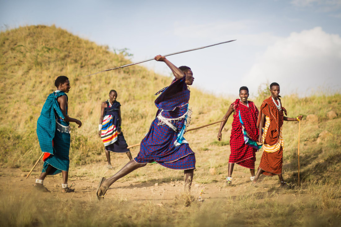 Die Massai in traditioneller Kleidung beim Werfen von Speeren